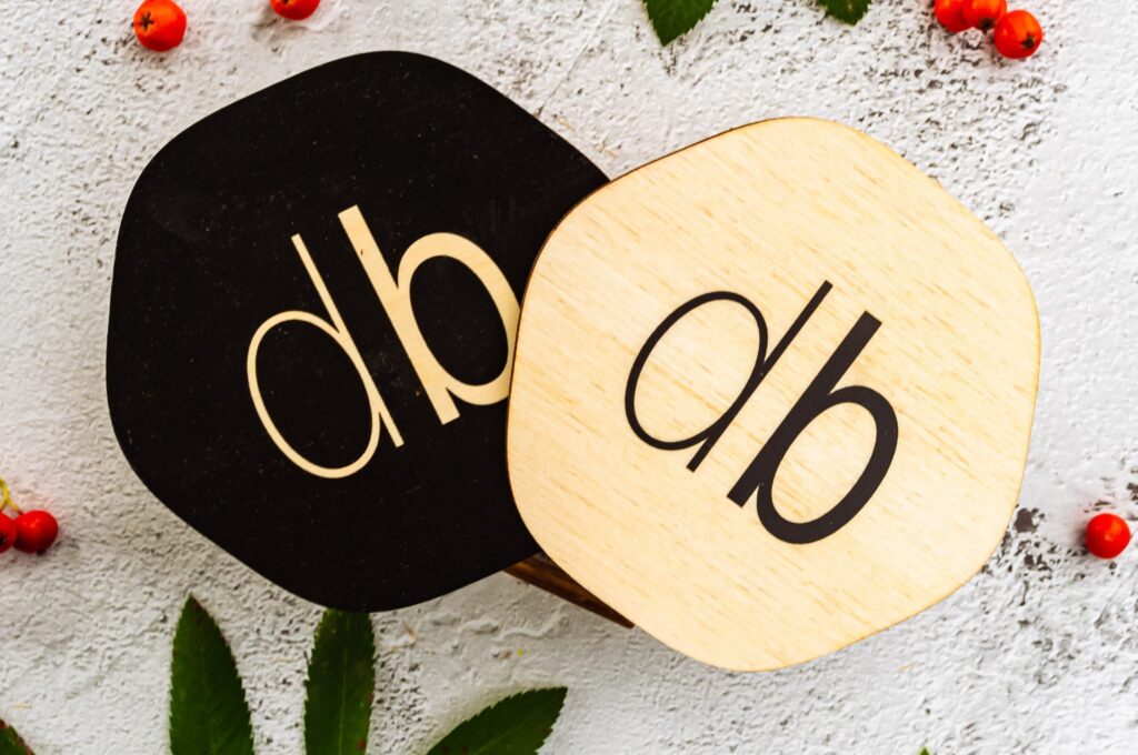 Sleek black and white coasters with an elegant and minimal logo.